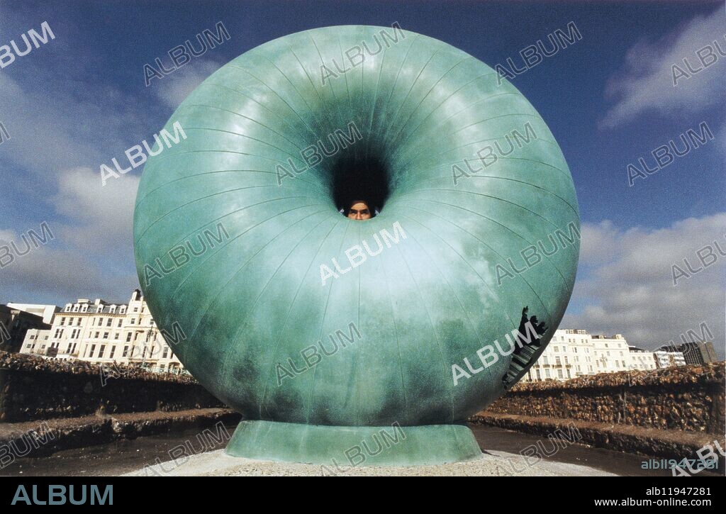 Sculptor Hamish Black peers through his imposing bronze sculpture on a groyne next to Brighton Palace Pier: Created by East Sussex sculptor Hamish Black, Afloat was unveiled in 1998. Its torus shape is supposed to represent what a black hole might look like. The 2.2 tonne bronze structure is 5 to 6mm thick and was winched on to the groyne with a crane. Based on a globe, the points at the north and south poles are pushed together through the sphere, forming a central hole where they meet. The work was commissioned by then Brighton Borough Council and funded through a National Lottery grant.