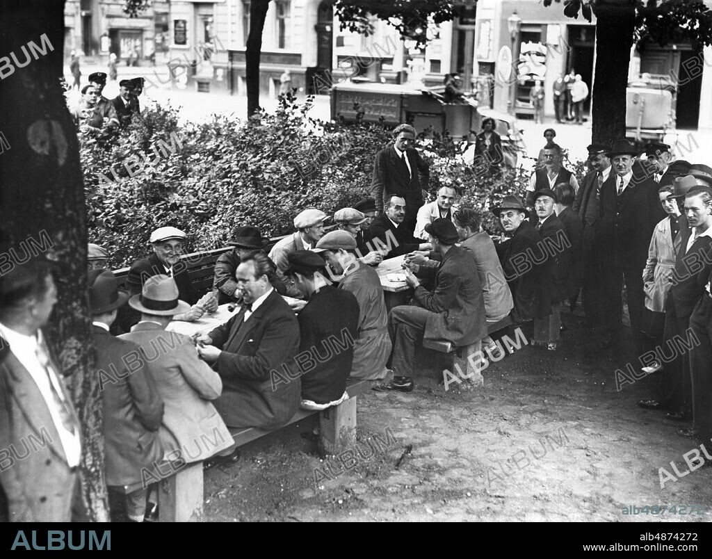 GERMANY BERLIN 1930s. Orig. caption ... TAXES ON PUBLIC BERLIN PLACES. A Berlin district has in its area on the green areas, on which to date over numerous unemployed to skate parties meet and in doing so mostly use the provided sand areas for children, tables and chairs for these stubborn, so-called skaters, skate players were occupied after the line-up. The administration thus hopes to remedy the inconveniences that have arisen between the unemployed and the parents of the children in the fields and at the same time provide the unemployed with some conveniences. Photo: Scherls Bilderdienst, Berlin / AB Text & Bilder / SVT / code: 5600 Note. Place for the unemployed who want to play the card game Tax Spectator Folder: Unemployment in Germany from the 1930s 2619A b / w copy sites: GERMANY; BERLIN PhotoDate: 193?.