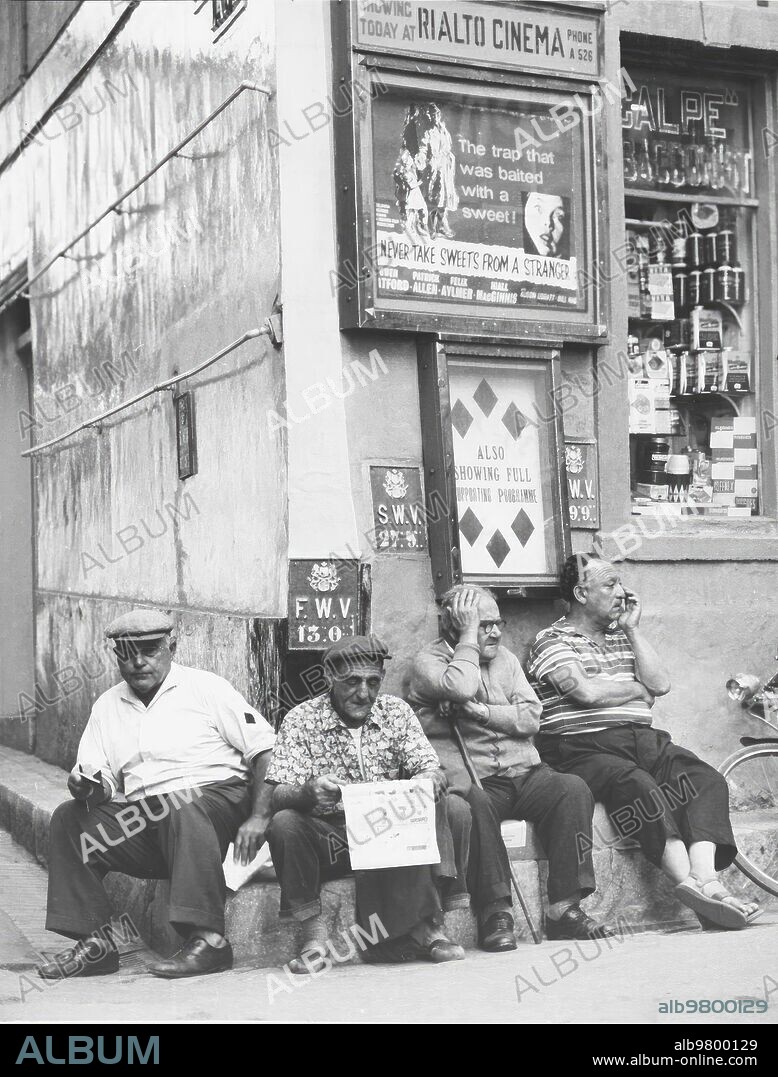 1963. Habitantes del peñón Descansando en una calle de Gibraltar.
