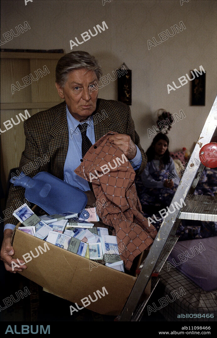 PRAXIS BÜLOWBOGEN / Lots of Coal (93) / 1995 / Eberhard Pieper / Dr. Brockmann (GÜNTER PFITZMANN) is looking for a hot water bottle for his patient - in the background: Petra Radke (ILONA SCHULZ) - and finds 400,000 DM ... - Episode: Lots of Coal (93).