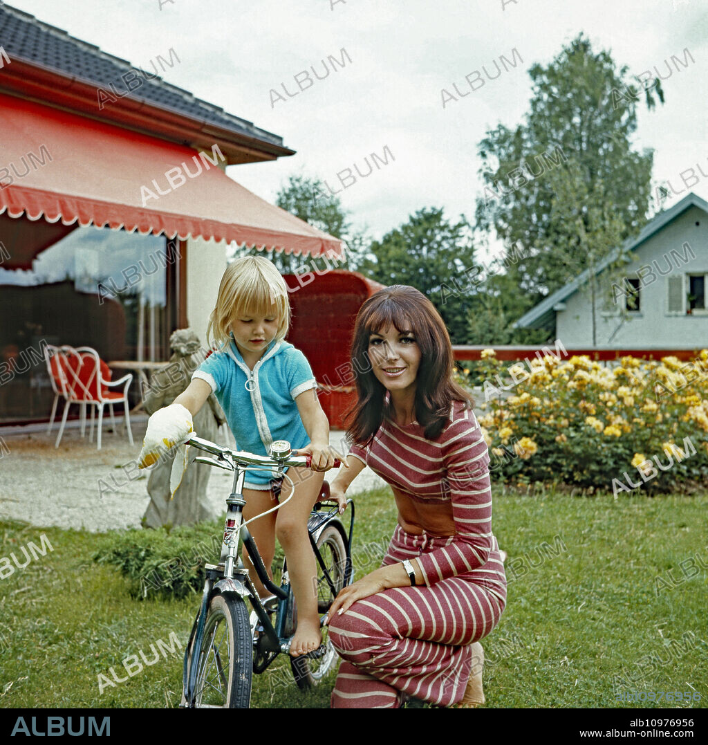 TV presenter Petra Schuermann playing with her daughter Alexandra Freund at Munich, Germany 1974.