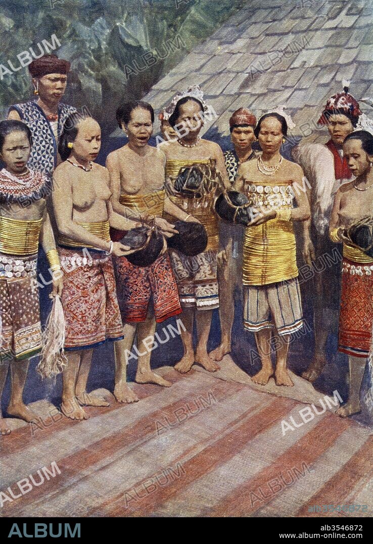 Dayak, Dyak or Dayuh women of Borneo, south east Asia, dancing with human heads. A few days after the return of a successful head-hunting expedition, the heads, which had been hacked off the dead bodies, were brought into the house. Then followed a time of rejoicing in the course of which the heads were taken by the women who, having performed fantastic dances, hung them beside the old ones. The presence of heads in the house was supposed to attract the benevolent spirits who lived around them. From Customs of The World, published c.1913.