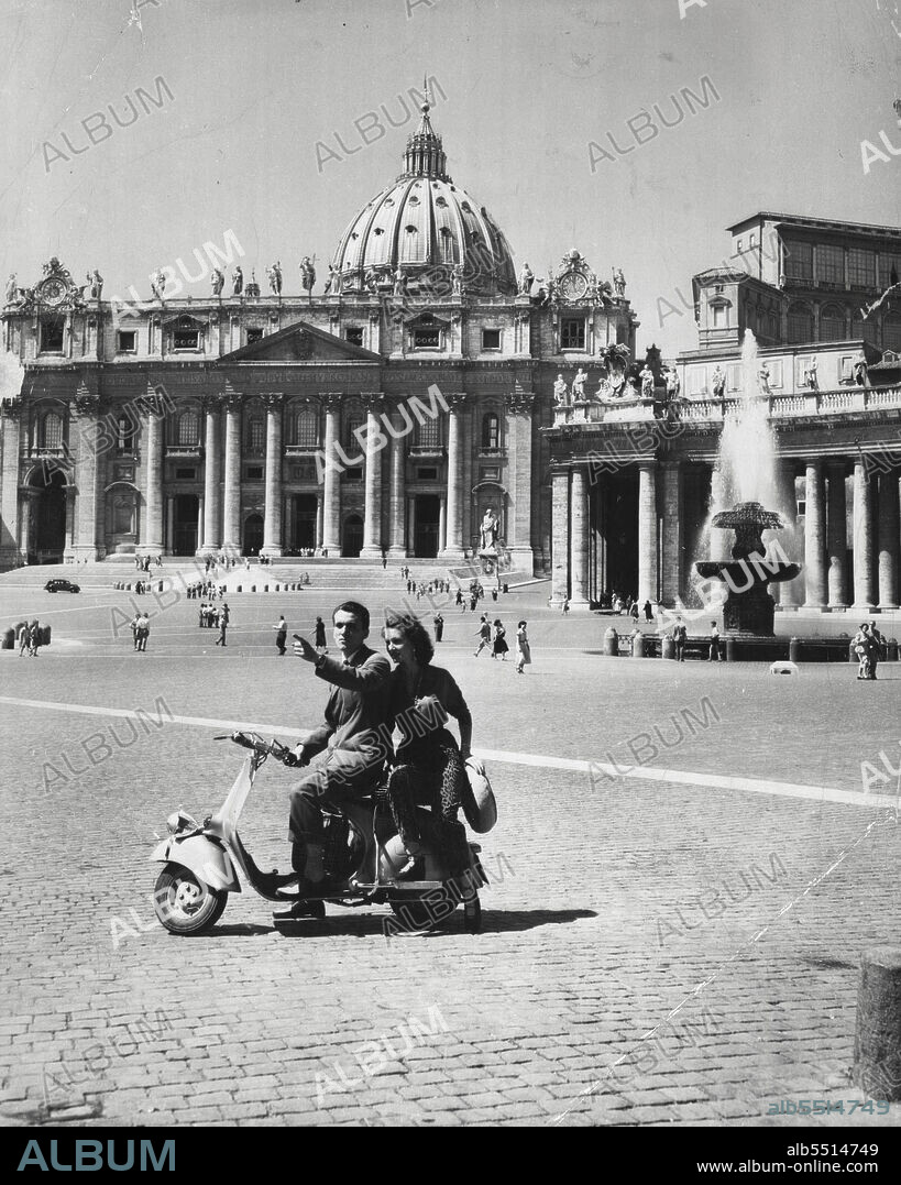 The Smaller The Better -- Compact little scooters like the Vespa, the Lambretta and the Libretta are a very popular means of transportation in Italy, and Tiny though they are, they can seat two.This young couple finds a motor scooter ideal for sight-seeing in Rome's St. Peter's Square. February 12, 1954. (Photo by United Press).