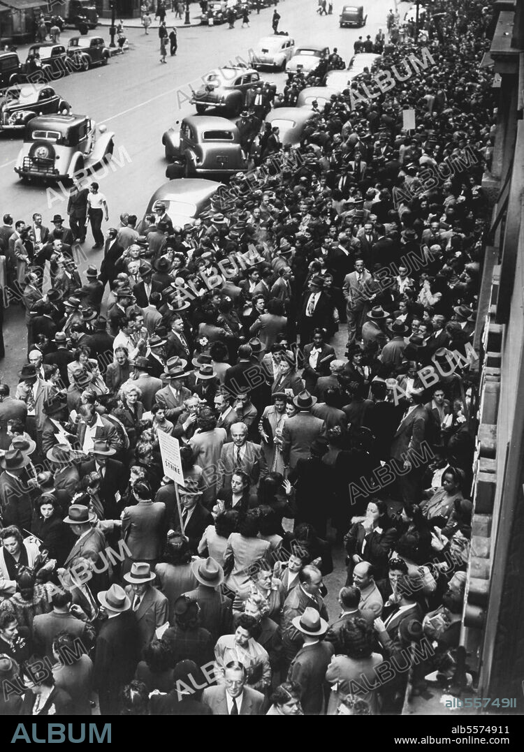 Elevator Strike Crowds Sidewalk: A picket (center, Foreground with sign) finds it hard to walk as workers in the garment section of New York, N.Y., crowd the sidewalk as they wait for the resumption of elevator service halted by the strike of building service employes, members of the AFL Building Service Employes International Union, during the morning rush hour, Sept. 24. This is a photo of Broadway looking South from 38th St. September 24, 1945. (Photo by Associated Press Photo).