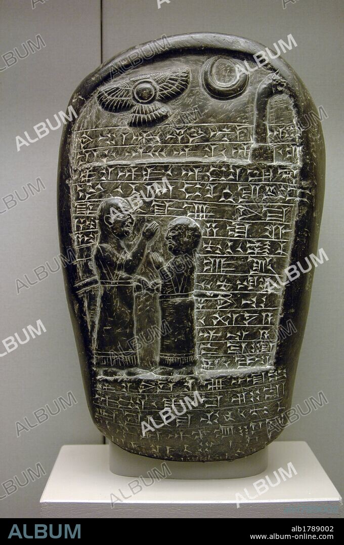 ARTE MESOPOTAMICO. BABILONIA. ESTELA CONMEMORATIVA de piedra, fechada entre los años 900-800 a. C. con la representacion de PADRE E HIJO con cabeza rapada lo que indica que ambos eran SACERDOTES. En la parte superior se representan tres SIMBOLOS DIVINOS. Presenta inscripción en ESCRITURA CUNEIFORME. En la antigua Mesopotamia era frecuente que el hijo adoptara la profesión del padre. Procede del templo de Marduk. Babilonia. Museo Británico. Londres. Inglaterra. Reino Unido.