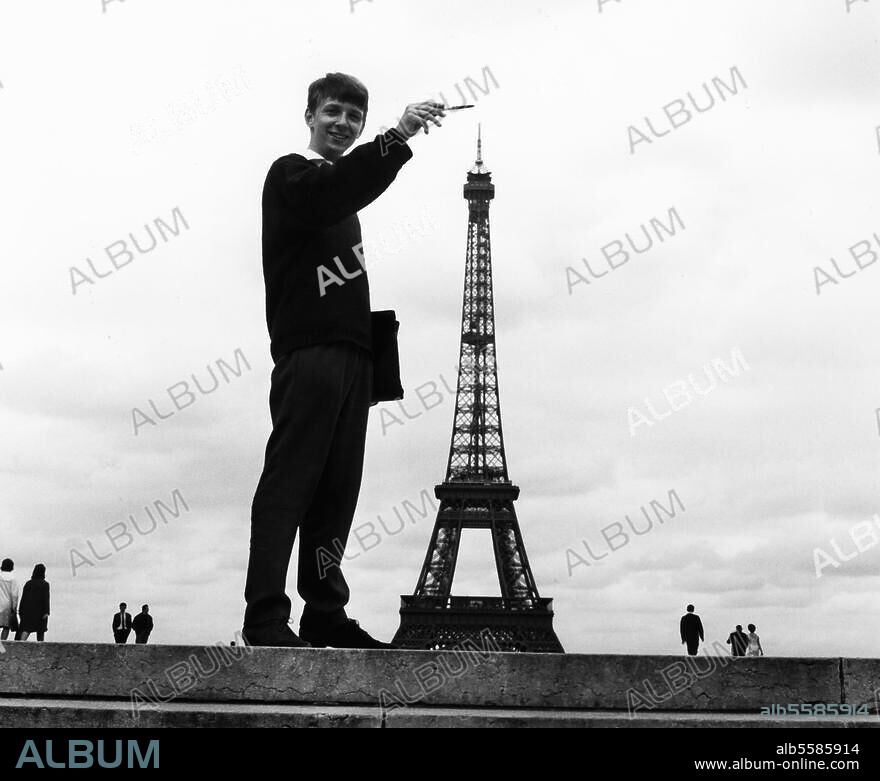 Paris, Eiffelturm. (1885-89 errichtet von G.Eiffel). Optische Täuschung: Der Eiffelturm aus einer Perspektive fotografiert, die ihn im Größenvergleich nur mannshoch erscheinen läßt. Foto, undat. (um 1960?). Aus einer Serie: Tour Eiffel.