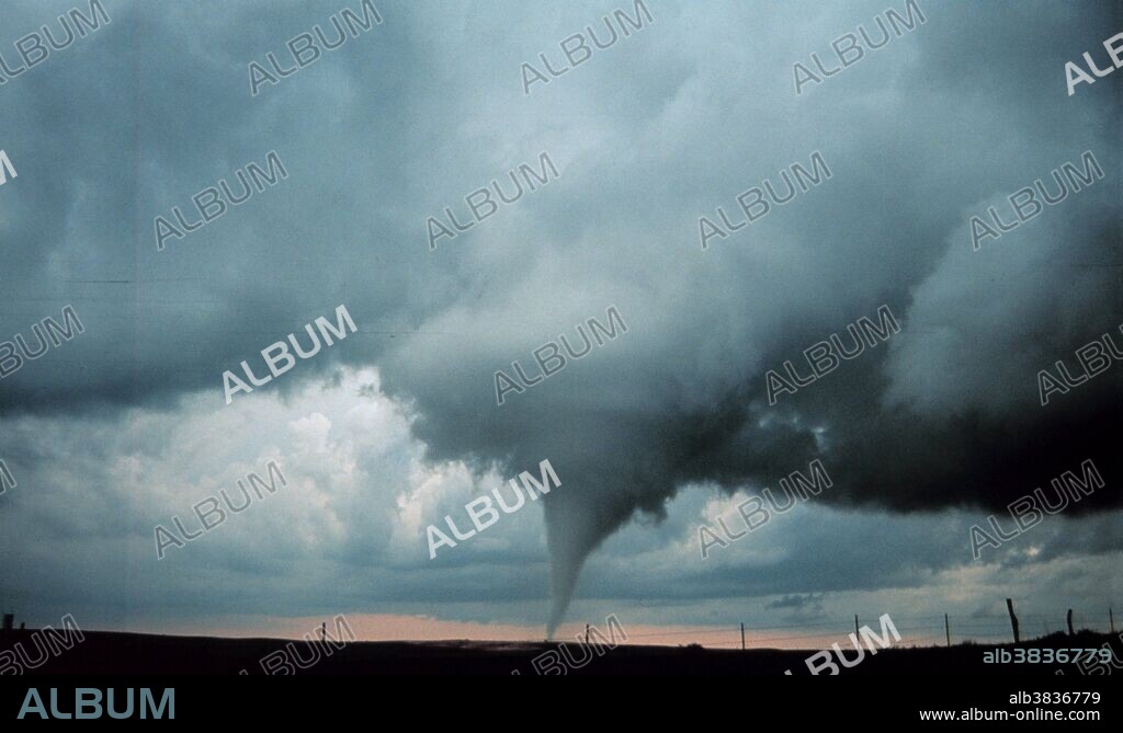 A tornado is a violent, dangerous, rotating column of air that is in contact with both the surface of the earth and a cumulonimbus cloud or, in rare cases, the base of a cumulus cloud. They are often referred to as a twister or a cyclone, although the word cyclone is used in meteorology in a wider sense, to name any closed low pressure circulation. Tornadoes come in many shapes and sizes, but are typically in the form of a visible condensation funnel, whose narrow end touches the earth and is often encircled by a cloud of debris and dust. Most tornadoes have wind speeds less than 110 miles per hour (177 km/h), are approximately 250 feet (80 m) across, and travel a few miles (several kilometers) before dissipating. The most extreme tornadoes can attain wind speeds of more than 300 mph (480 km/h), stretch more than two miles (3 km) across, and stay on the ground for dozens of miles (more than 100 km). Project Vortex-99. Occluded mesocyclone tornado. Occluded means old circulation on a storm; this tornado was forming while the new circulation was beginning to form the tornadoes which preceeded the F5 Oklahoma City tornado. Photo #2 of sequence. Oklahoma 8 miles south of Anadarko May 3, 1999.