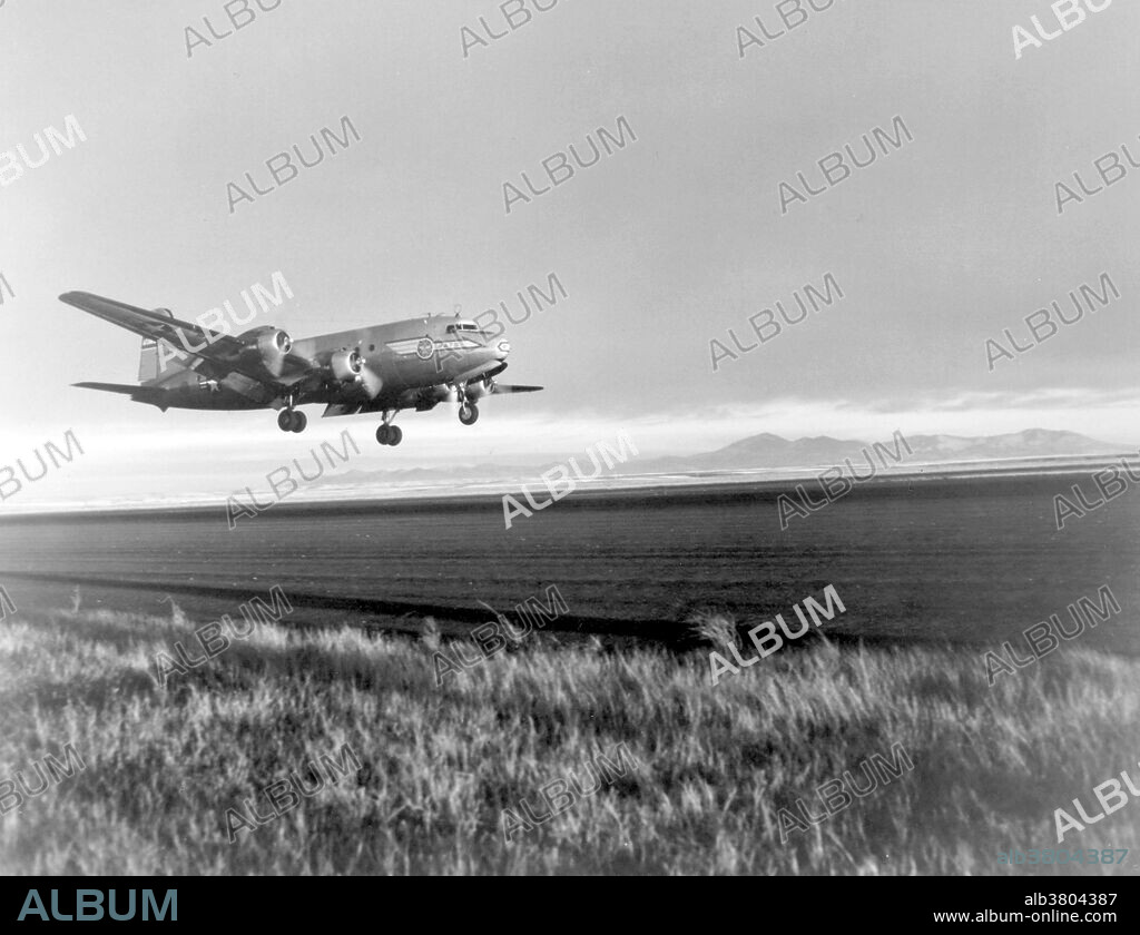 A Douglas C-54 Skymaster practices a "Tempelhof Landing" at Great Falls Air Force Base, Montana. Student pilots are taught this special type of landing to simulate flight conditions at Tempelhof AB, Berlin. The approach glide angle is very steep and the airplanes touch down with a high-nose altitude and are held nose-high until engines slow down. This causes the wing to act as an airbrake and use of the wheel brakes is cut to a minimum. The Douglas C-54 Skymaster was a four-engined transport aircraft used by the United States Army Air Forces in WWII and the Korean War. Like the Douglas C-47 Skytrain, the C-54 Skymaster was derived from a civilian airliner, the Douglas DC-4. Besides transport of cargo, the C-54 also carried presidents, prime ministers, and military staff. Dozens of variants of the C-54 were employed in a wide variety of non-combat roles such as air-sea rescue, scientific and military research, and missile tracking and recovery. During the Berlin Airlift it hauled coal and food supplies to West Berlin. After the Korean War it continued to be used for military and civilian uses by more than 30 countries.