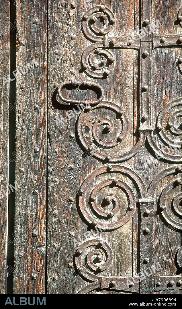 DETALLE DE LA PUERTA DE MADERA CON REMACHES DE HIERRO EN ESPIRAL.