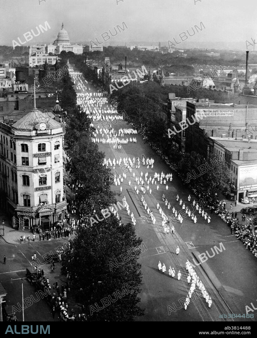 Ku Klux Klan march on Pennsylvania Avenue in Washington, D.C. on September 13, 1926, with Franklin National Bank in the foreground and the US Capitol in the background. In 1915 the film The Birth of a Nation was released, mythologizing and glorifying the first Klan and its endeavors. The second Ku Klux Klan was founded in 1915 by William Joseph Simmons at Stone Mountain, outside Atlanta, with fifteen charter members. Its growth was based on a new anti-immigrant, anti-Catholic, prohibitionist and anti-Semitic agenda, which reflected contemporary social tensions, particularly recent immigration. The new organization and chapters adopted regalia featured in The Birth of a Nation; membership was kept secret by wearing masks in public. By the mid-1920s the second Klan had a nationwide reach, with its densest per capita membership in Indiana. The Klan became most prominent in cities with high growth rates between 1910 and 1930, as rural Protestants flocked to jobs in Detroit, and Dayton in the Midwest; and Atlanta, Dallas, Memphis, and Houston in the South. Photographed by the National Photo Company, 1926.