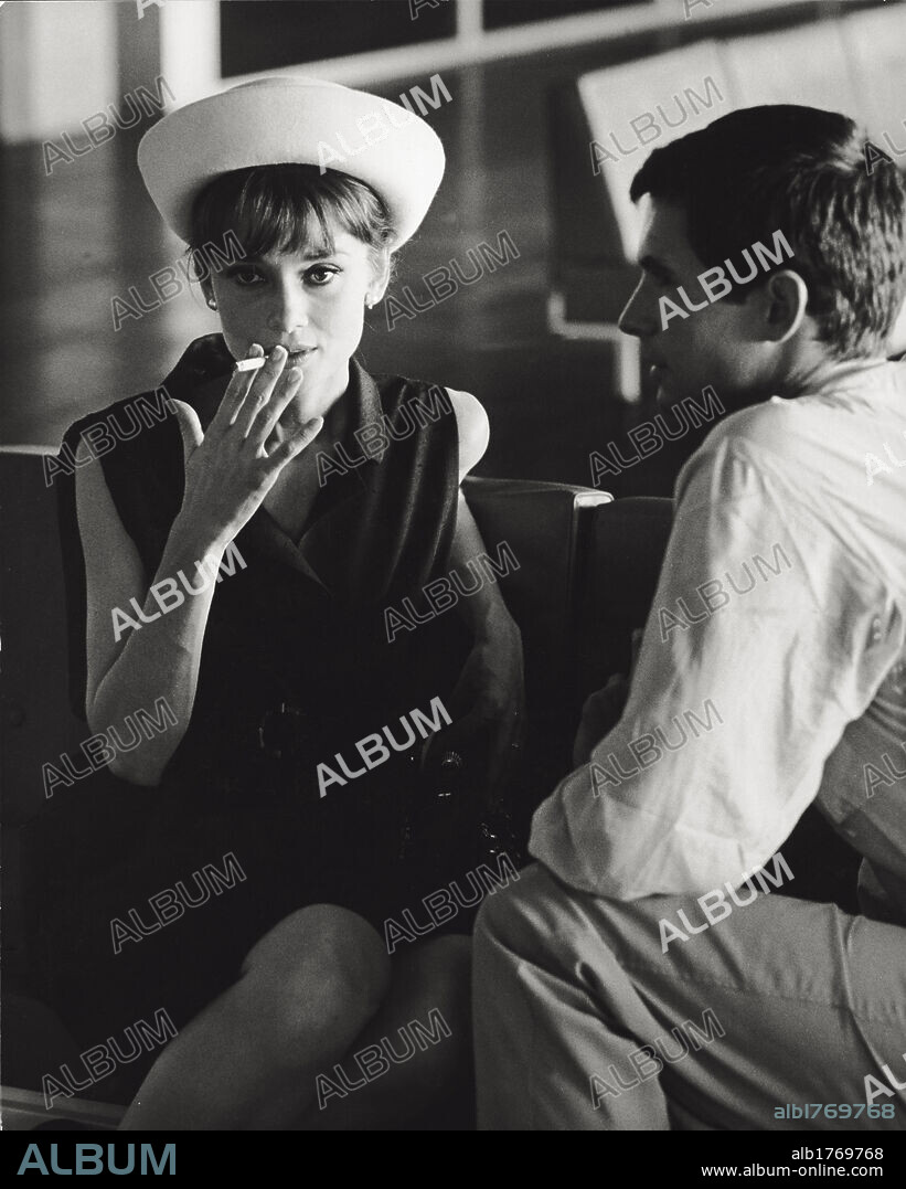 Audrey Hepburn and Anthony Perkins. The British actress Audrey Hepburn smoking a cigarette while sitting next to the American actor Anthony Perkins. Paris, July 1962.