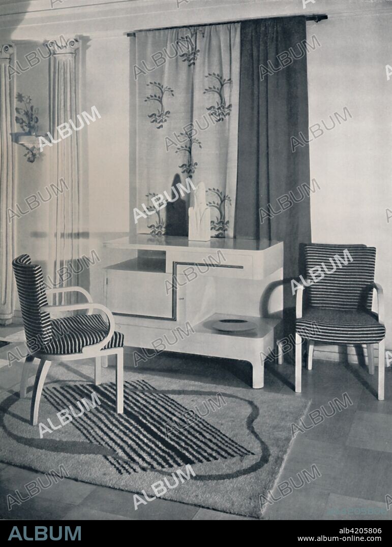 'Corner of a room designed by Hayes Marshall for Fortnum & Mason Ltd., London', 1936. Floor of natural polished birch squares, hand-tufted rug by Marion Dorn. Sycamore side-table with walnut trim, designed by Osborne Hill. Sycamore chairs with saddle seats, designed by Hayes Marshall. From Decorative Art 1936 - Year-Book of The Studio, by C.G. Holme. [The Studio Limited, London, 1936].