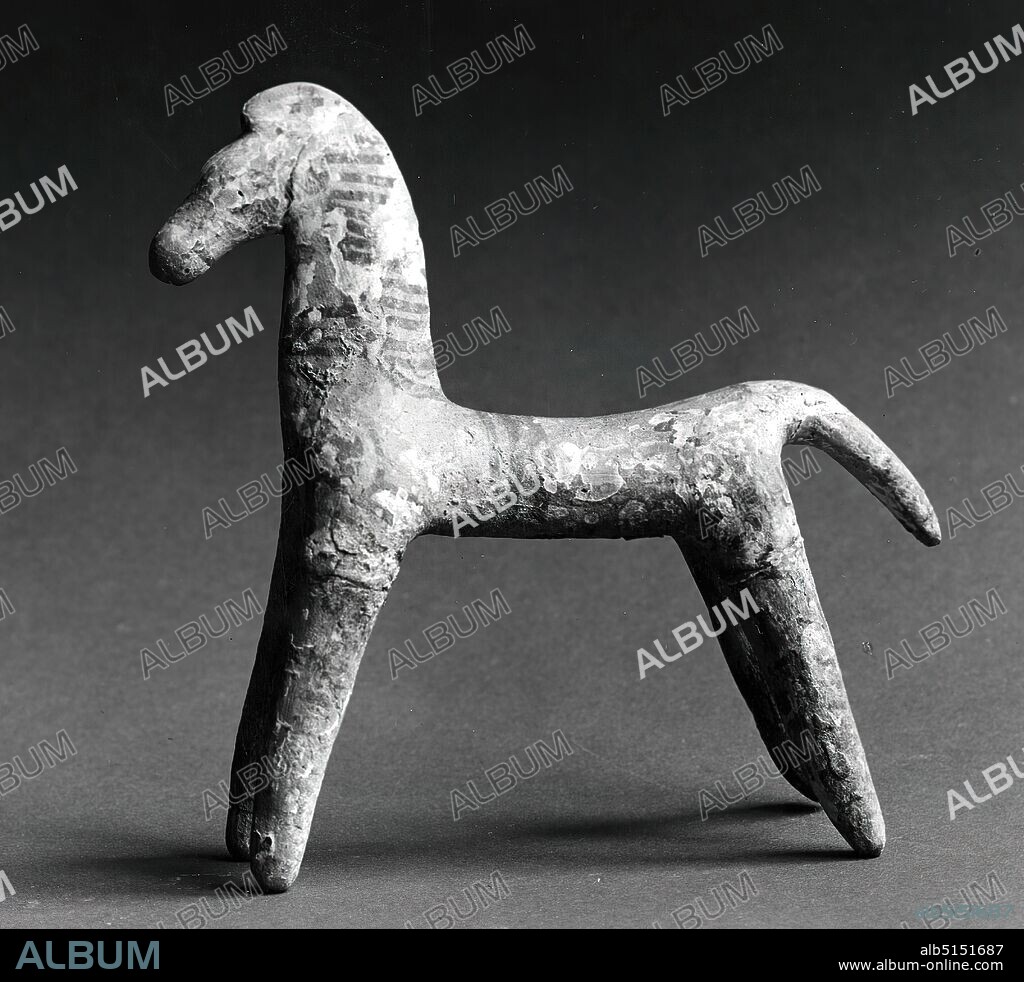 horse, Formerly Johannes W. F. Collection Reimers (Hamburg), clay, hand-modeled, fired (ceramic), painted (ceramic), cold painting, clay, Total: Height: 13 cm; Width: 13.3 cm; Depth: 4.2 cm, ceramic, small sculptures/small works of art, three-dimensional sculptures, grave goods, horse, Middle Archaic, Greek antiquity, Slender, stylized horse with neck and head flattened at the sides. The tail is short and flattened like a beavertail. The flared legs are not jointed. The neck is painted with transverse parallel lines; three circular lines run around the trunk. Two red stars are on the croup. The noseband of the bridle is painted on. In Boeotia, Brettidole, riders and horses are found together in graves. The horse has different meanings: On the one hand it belongs to the death and death cult, on the other hand it is a status symbol of the aristocracy. Perhaps the heroic character of the deceased is to be praised.