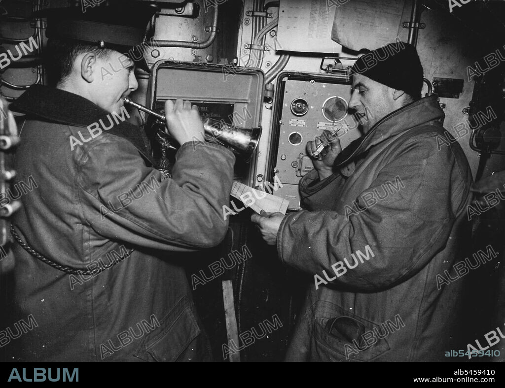 Convoy To Russia: With A British Cruiser Escort On Arctic Lifeline - Twice daily the Bos'n's mate pipes "For exercise only, hands to action stations," and the Royal Marines' drummer sounds off the call to action stations.
A fast British cruiser sets out to rendezvous with a convey of merchantmen, some of them Russian, heavily laden with arms for the Red Army. The crew receives an issue of arctic clothing. The convoy escorted by British minesweepers, is met in the dark.
For the rest of the voyage they remain almost in darkness, for in these latitudes the sun is not seen for three months in winter a an hour or two of dawn, then twilight and night again. September 9, 1952. (Photo by British Official Photograph).