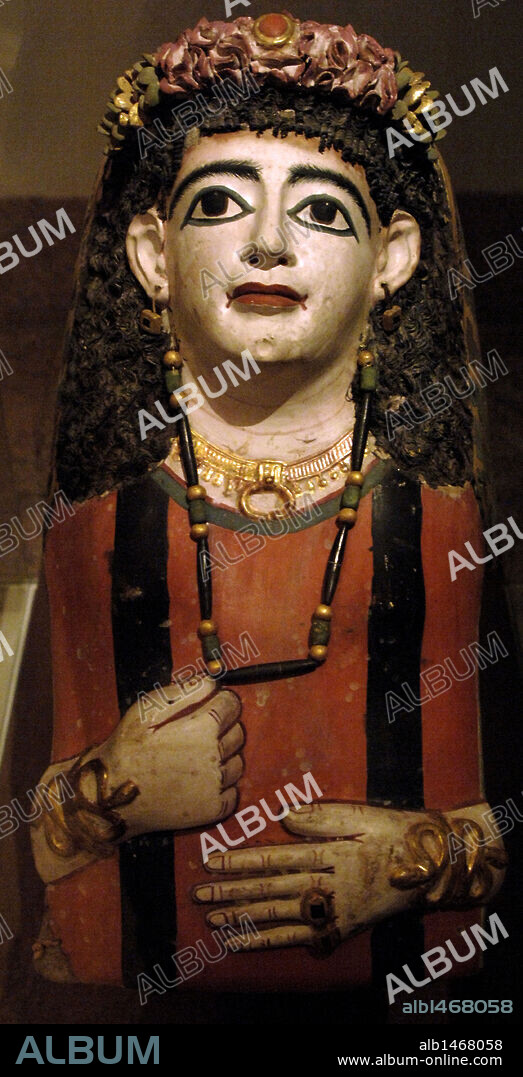 ARTE EGIPCIO. EGIPTO. DOMINACION ROMANA. MASCARA DE LA MOMIA DE UNA MUJER ENJOYADA CON UNA GUIRNALDA (años 60-70 d. C.). S. I. Probablemente proceda de una tumba de la necrópolis de Meir. Se le ha representado como si estuviera estirada sobre un ataúd. Lleva una peluca de fibras vegetales, túnica de rayas y diversas joyas como los dos brazaletes con forma de serpiente. Museo Metropolitano de Arte. Nueva York. Estados Unidos.