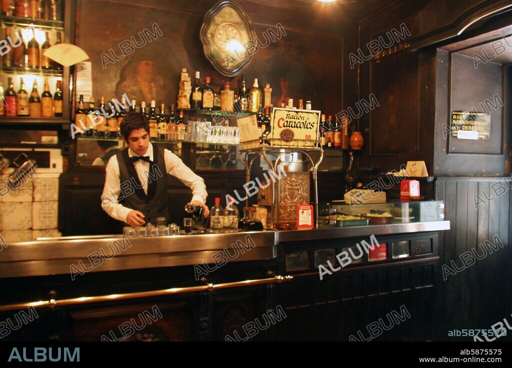 Bar "La Taberna de Antonio Sánchez" (barrio Tirso de Molina); camarero sirviendo copa de vino en la tradicional barra.