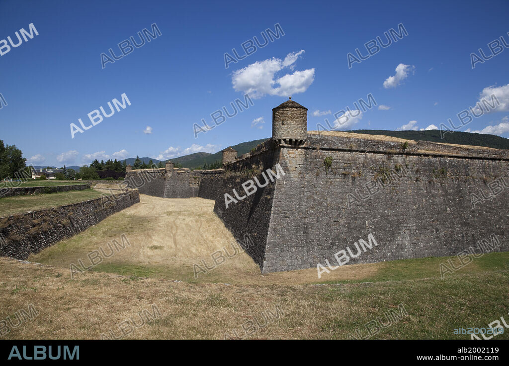 Jaca Citadel had been called  the San Pedro (Saint Peter) Castle until the 19th century. It was built from 1595 until the late 17th century, to secure the frontier with France and to prevent the Huguenot army from entering Spain through the Santiago pilgrimage route. The castle was designed by the Italian Knight Commander Tiburcio Spanich in the shape of a pentagon with a turret made of stone ashlars at each angle. The citadel is surrounded by a defensive wall, a dry moat and a glacis. Inside the citadel is a courtyard, surrounded by walls with machicolations. The castle is the only military construction of its kind in Spain to survive completely intact. It was declared a National Monument in 1951.