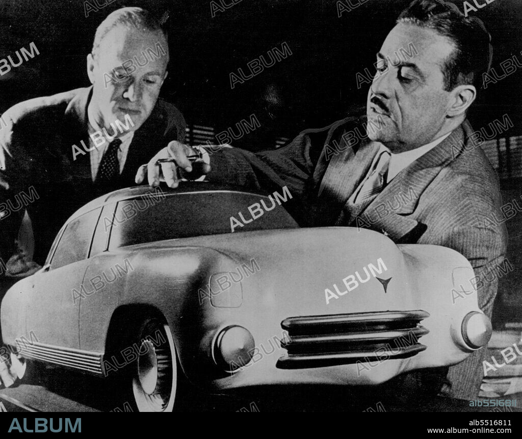 Raymond Loewy, U.S. designer (right), discusses his car of the ***** with a draftsman. Its innovations include a plastic and glass body structure, individual reclining seats movable rear section for open-air driving. November 3, 1944.