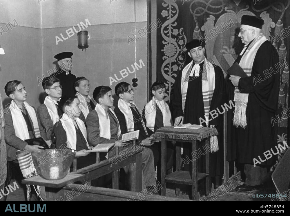 Religionen / Jüdische Religion:. Bar Mizwa (religiöse Mündigkeitserklärung des Dreizehnjährigen) im Betraum in der Pestalozzistraße in Berlin-Charlottenburg mit Kantor Estrogono Nachama und Prediger Klein (re.). Foto, Dezember 1948 (Abraham Pisarek).