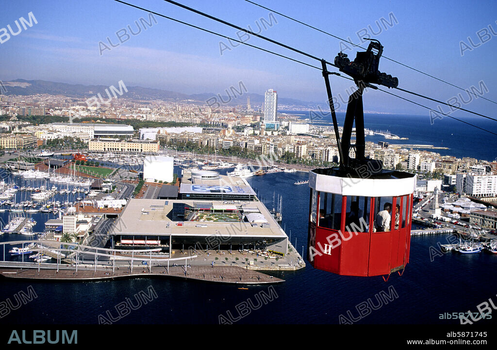 Teleférico (Funicular Aéreo), sobre el puerto; "Maremagnum" y al fondo Barceloneta y Villa Olímpica.