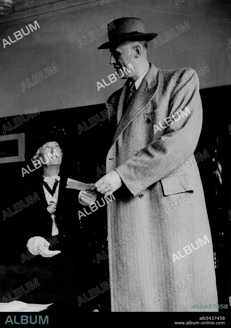 "High Benevolence" - Tall Dutchman Presents Cheque to Woman Mayor for European Children - Jan Van Albert, of Amesterdam, Holland, who is nine feet, three inches tall, aged 45, presenting Mrs. Macbain Taylor, the Mayor of Lowestoft, a cheque for fifty-five pounds, for the Mayor's Fund to the United Nations Association for European Children. The money was collected from Lowestoft children at a show he was appearing in. April 13, 1948. ;"High Benevolence" - Tall Dutchman Presents Cheque to Woman Ma.