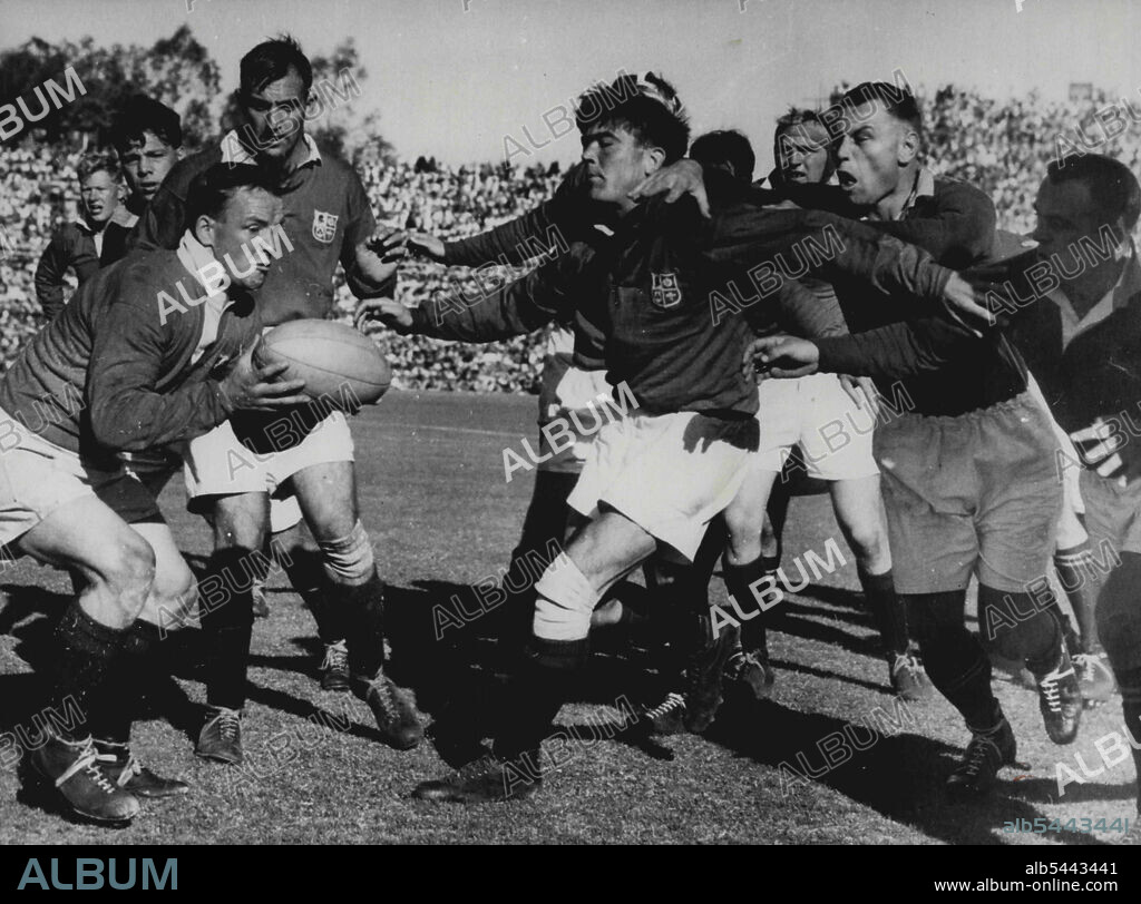 Lions Win The Third Test - Bryn Meredith, Welsh Hooker of the British Isles Side (the lions) throws out a protective screen as his scrum half Dicky Jeeps, gets the ball from a line out in the third Rugby International, in Pretoria, September 3. Britain beat South Africa 9-6. Chris Koch, the Springbok forward, his face contorted with effort, tries to break past Meredith with Bertus Van Der Merwe, the Springbok Hooker, at right. September 16, 1955. (Photo by Associated Press Photo).