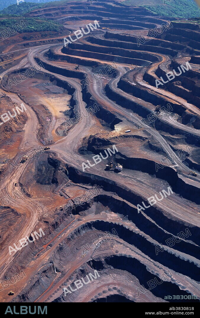 Iron mine. Opencast iron mine in the Amazon rainforest of Brazil. This is the Carajas iron mine, one of the largest of its kind in the world. 45 million tonnes of iron ore is extracted here each year. The forest has been clear cut to provide access to the enormous deposits of iron ore. Despite the obvious negative impacts on the environment, including loss of biodiversity and pollution, the company that runs the mine, Cia Vale do Rio Doce (CVRD), has been praised for its environmentally sound practices and for protecting a far greater area of rainforest than it uses.