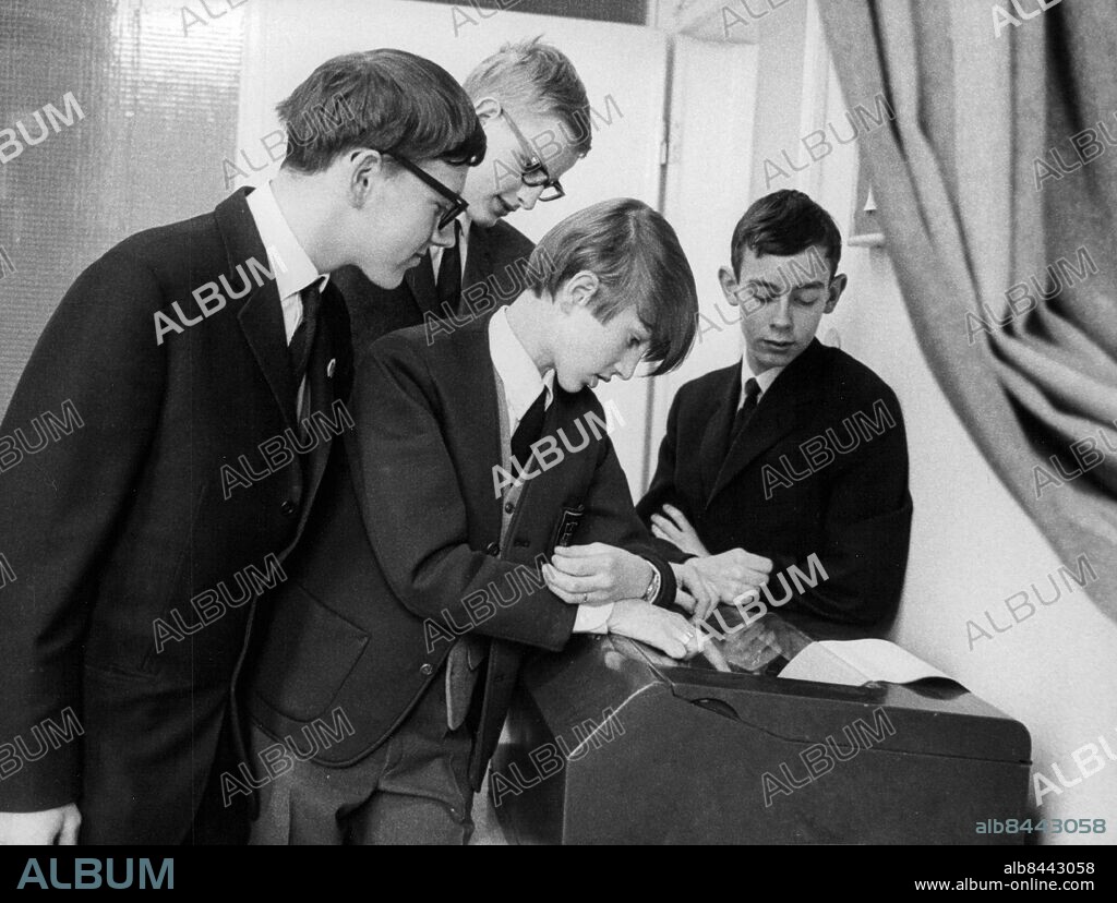 Stockholm 1965-02-14. Staffan Hildebrand, Carl Bildt, Claes Jalander och Krister Andersson bekantar sig med teleprintern vid Svensk elevpress årsmöte på Journalistinstitutet. Foto: John Kjellström / SvD / TT / kod 12014.
