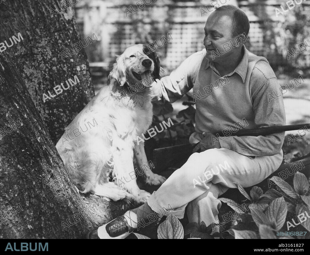 Atherton, California: July 11, 1936. Baseball star Ty Cobb relaxes with his dog after hunting.