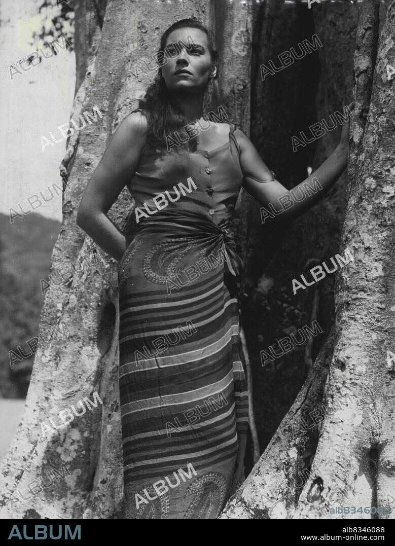 Kerima On Location -- Sultry star of the east Kerima - 22-year-old Arab girl - leans against a tree in a native costume as she is shown here in the first picture sent back from film-maker Carol' Read' unit on location in Ceylon.Kerima plays the role of Aissa in the new film, which is based on the Joseph Conrad novel 'An Outcast of the Islands'.Reed found the girl for the part after a search that took him half-way around the world. December 7, 1950. (Photo by Reuterphoto).