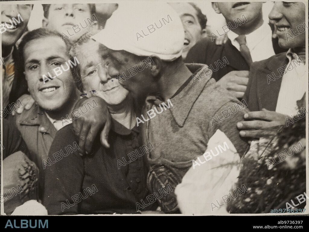 Madrid, 05/31/1936. Final of the cycling Tour of Spain. In the image, Julián Berrendero hugs his mother upon reaching the finish line Photo: Díaz Casariego. On the runner's shirt, the Real Madrid shield.
