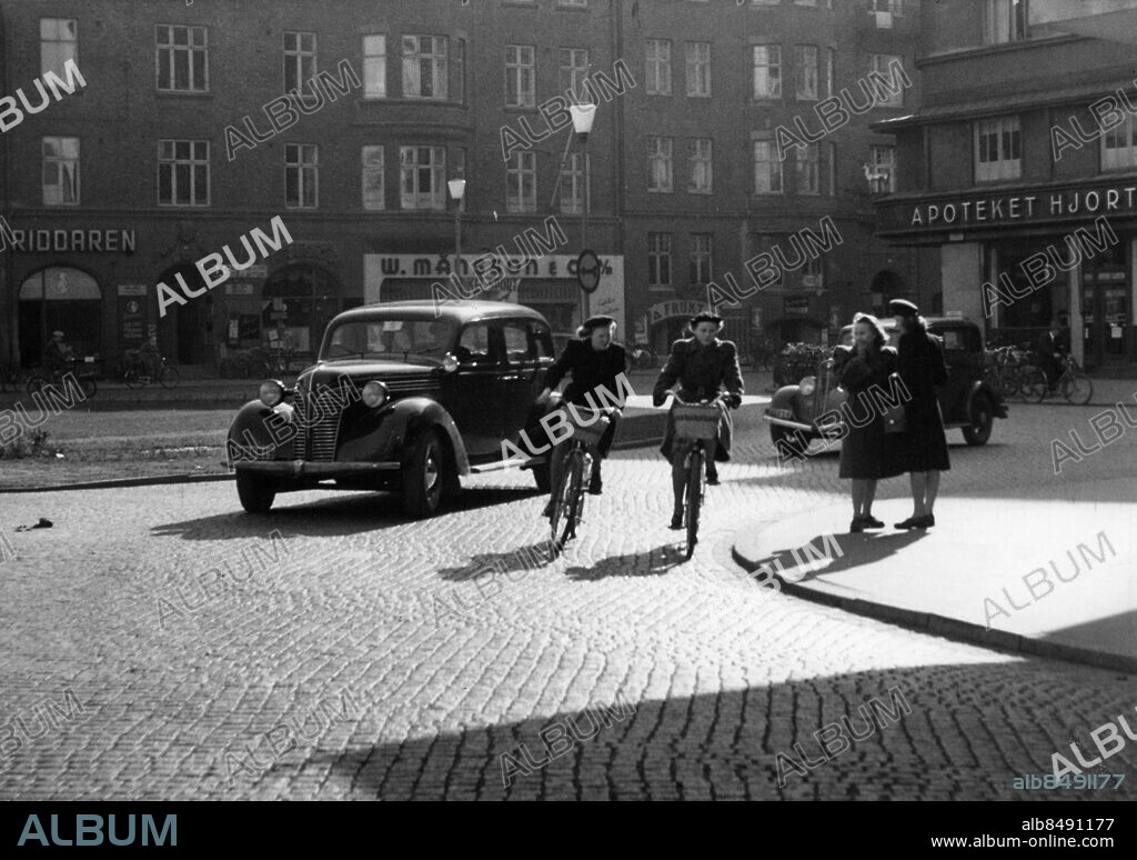 Triangeln i Malmö 1948 där cyklister cyklande damer och personbil är på väg in på Södra Förstadsgatan rikning Gustav Adolfs Torg GAT.. Foto: Sydsvenskan / IBL Bildbyrå.