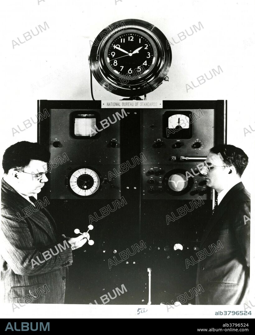 Edward Condon (at left) with the first atomic clock. Edward Uhler Condon (March 2, 1902 - March 26, 1974) was a distinguished American nuclear physicist, a pioneer in quantum mechanics, and a participant in the development of radar and nuclear weapons during WWII as part of the Manhattan Project. He was the director of the National Bureau of Standards (now NIST) from 1945 to 1951. An atomic clock is a clock device that uses an electronic transition frequency in the microwave, optical, or ultraviolet region of the electromagnetic spectrum of atoms as a frequency standard for its timekeeping element. The principle of operation of an atomic clock is not based on nuclear physics, but rather on atomic physics; it uses the microwave signal that electrons in atoms emit when they change energy levels. The first atomic clock was an ammonia maser (microwave amplification by stimulated emission of radiation) device built in 1949 at the U.S. National Bureau of Standards (NBS, now NIST). The world's first atomic clock using the ammonia molecule as the source of vibrations.