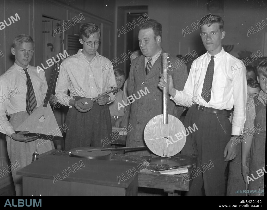 Göteborg 1937-06-08 - Avslutning i skolan - Slöjdlärare Ivar Andersson på Landalaskolan i kretsen av instrumentförfärdigande elever. Nr 2 fr v har en träslevsbalalajka, medan pojken längst th har ett instrument gjort av en sikt - *** Local Caption *** GT Låda 1937-juni-01. KAMERAREPORTAGE.