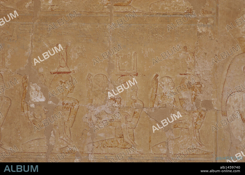 ARTE EGIPCIO. EGIPTO. Relieves con la representacion de mujeres arrodilladas abrazando un niño y portando en la cabeza un escudo con dos flechas (equivalencia femenina del Ka), y hombre arrodillado abrazando un niño y portado el símbolo ka (masculino). Dualidad. Templo de Hatshepsut. Deir El-Bahari. Región Tebana.