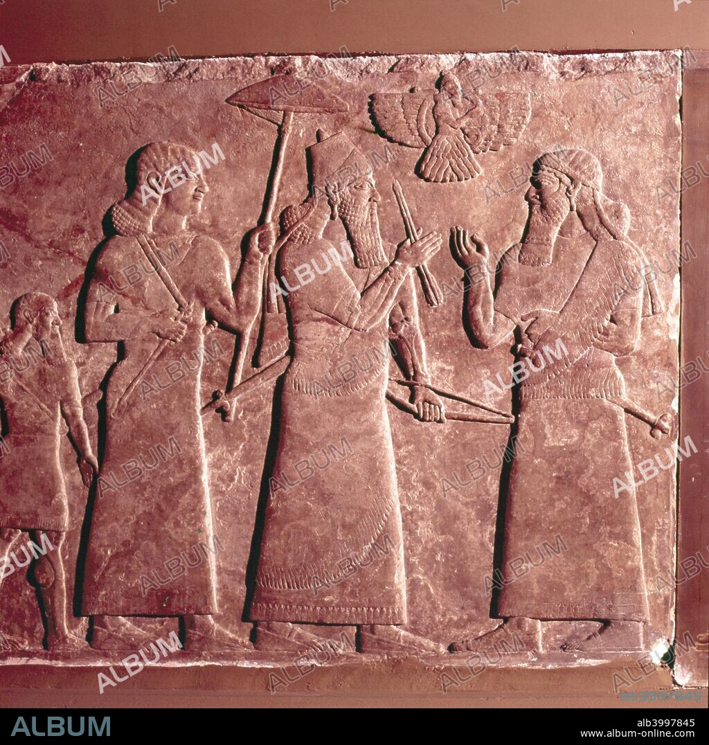 Assyrian Relief,  Ashurnasirpal II with attendants, 9th century BC. Above is the winged figure of the god Ashur, Ahura Mazda. British Museum.