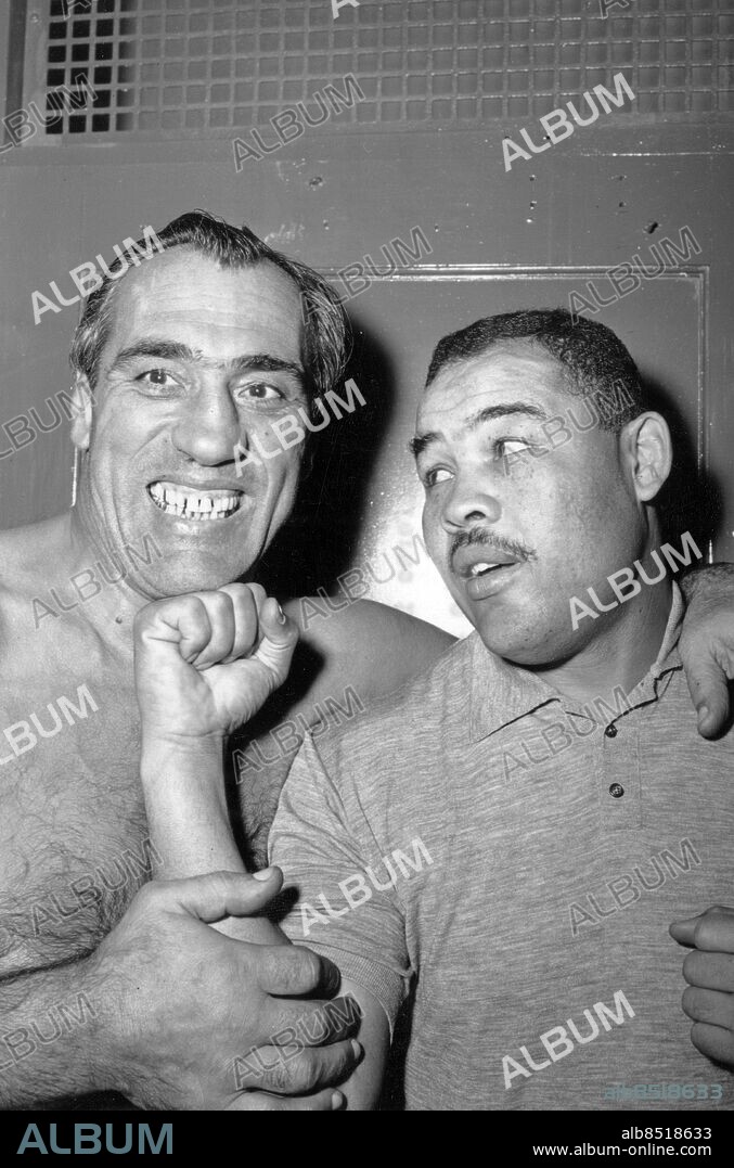 KANADA TORONTO 1955-12-02.. Joe Louis (th), amerikansk fd tungviktsboxare, är domare i en brottningsmatch där Primo Carnera (tv), italiensk professionell boxare och brottare, deltar. De båda tävlade en gång i tiden om världsmästartiteln i tungviktsboxning.. Foto: Federal Newsphotos of Canada / Text & Bilder / SVT / Kod: 5600. Engelsk originalbildtext.. Mapp: Louis, Joe boxaren: träning, uppvisningsmatcher, sportande.