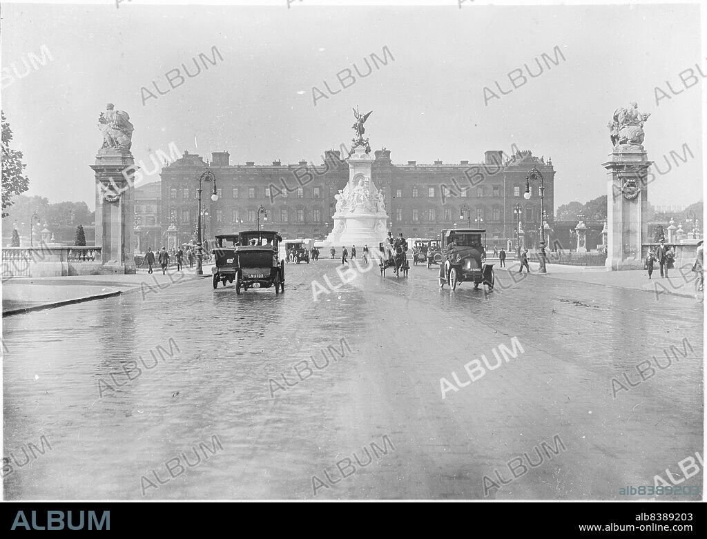 Buckingham Palace, The Mall, St James, City of Westminster, Greater London Authority, 1911. A view from the Mall of Buckingham Palace, showing the Queen Victoria Memorial fountain and gate piers, with motor cars and a horse-drawn carriage in the foreground.