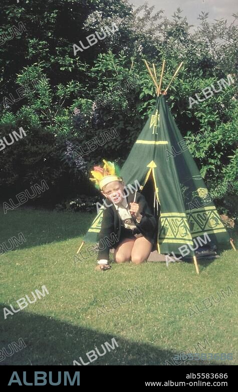Kinderspiele:. Indianerspiel. Junge mit Federhaube, Kriegsbeil und Zelt im Garten. Amateuraufnahme (Kleinbilddia), Berlin, 1965.
