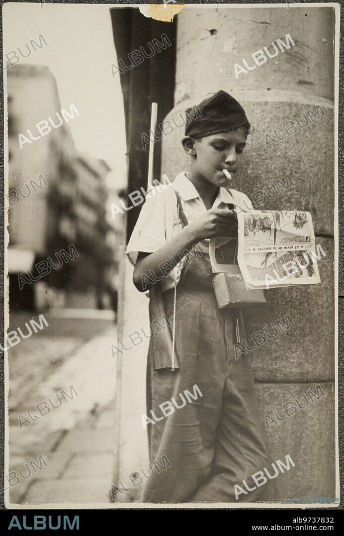 1937. A child armed and smoking on the streets of Madrid during the Civil War.
