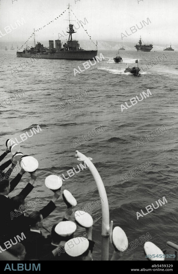 The King Reviews Britain's Reserve Fleet In Weymouth Bay - The Royal barge, with the King on Board, passing H.M.S. Caradoc during the inspection of the reserve fleet by the King in Weymouth day today, August 9. Note the men on H.M.S. Dunedin, Bottom left hand corner cheering the King as the Royal Barge Approaches.
The Royal review of Britain's reserve fleet, drawn up in Weymouth Bay, took place today. August 9. The King arrived from Scotland, where the court is at present in resident at Balmoral castle, at 10 a.m. This morning and immediately embarked in the Royal barge for the Royal yacht Victoria and Albert. August 09, 1939. (Photo by Associated Press Photo).