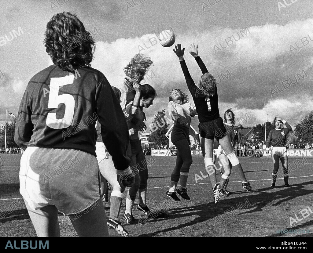 ARKIV MARIEHAMN 19730825. Kamp om bollen framför det finska målet vid Sveriges första fotbollslandskamp för damer. Matchen spelades mot Finland i Mariehamn på Åland och slutade 0-0. Ann Jansson klättrar på ryggen på medspelaren Ann Magnusson och Birgitta Söderström i mitten försöker nå upp till bollen. Finlands målvakt Luomanperä lyckas dock reda ut situationen.. Foto: DN / SCANPIX / Kod: 192. **SVD OUT**.