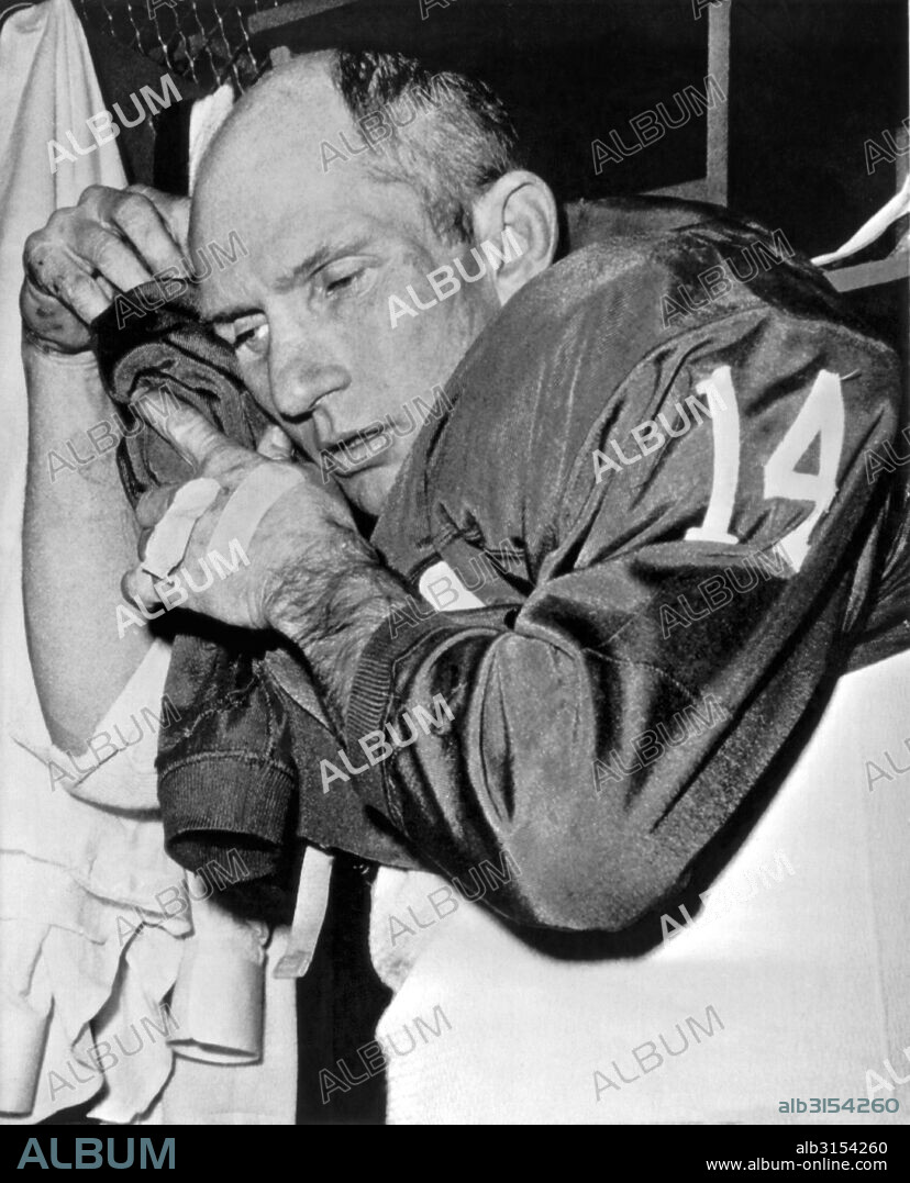 New York, New York:  December 16, 1963. New York Giants quarterback Y.A. Tittle gingerly sheds his uniform in the dressing room at Yankee Stadium after leading his team to victory over Pittsburgh, 33-17, to win the NFL Eastern Conference title for the third year in a row.