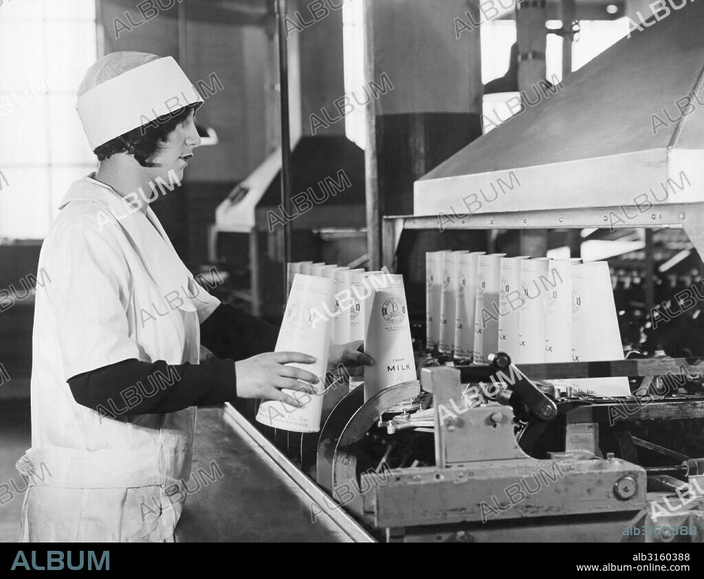 New York, New York:  c. 1928 Sheffield Dairy Farms workers using the new Sealcone paper containers in which to pack milk, replacing the glass bottle. They are lighter, they don't break, and pack twice as efficiently due to their conical shape. Here the containers are being coated with paraffine to keep them from leaking.