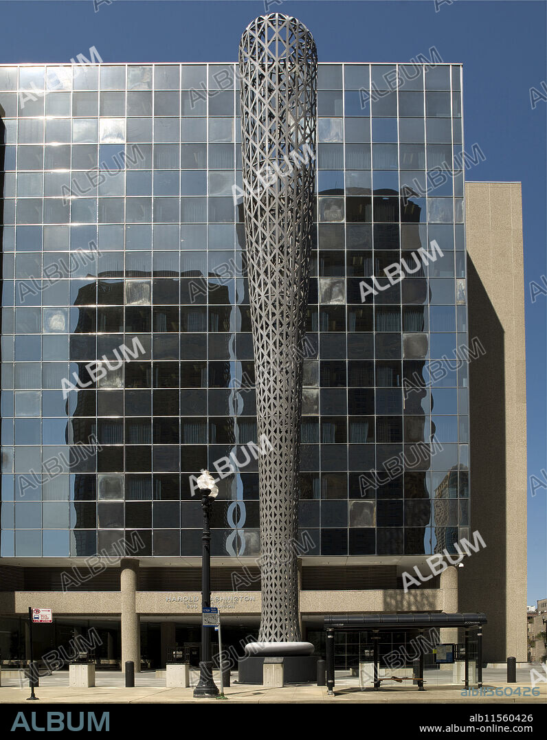 Batcolumn stands outside the Harold Washington Social Security Administration Building at 600 West Madison Street near downtown Chicago. The United States General Services Administration commissioned the sculpture, which was dedicated in 1977. Oldenburg originally designed the sculpture to be painted red, but he abandoned that idea to distinguish it from Chicago's Flamingo sculpture by Alexander Calder. Oldenburg instead had Batcolumn painted gray, which he also hoped would make the sculpture easier to see against the sky. A plaque on the sculpture reads, "Oldenburg selected the baseball bat as an emblem of Chicago's ambition and vigor. The sculpture's verticality echoes the city's dramatic skyline, while its form and scale cleverly allude to more traditional civic monuments, such as obelisks and memorial columns.