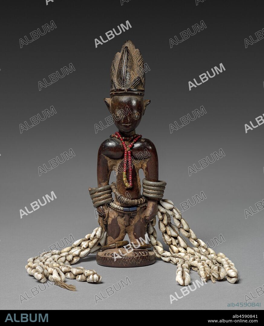Memorial Figure (Ere ibeji), late 1800s-early 1900s. Such a figure is carved when a twin dies in infancy and serves as a memorial to the surviving sibling. These twin figures are always carved to look like adult individuals with idealized physical features. Various body adornments suggest the care parents devote to their children, while the erosion of facial features indicates the symbolic washing and feeding of the figure as a means to connect the soul of the deceased to that of the living twin.