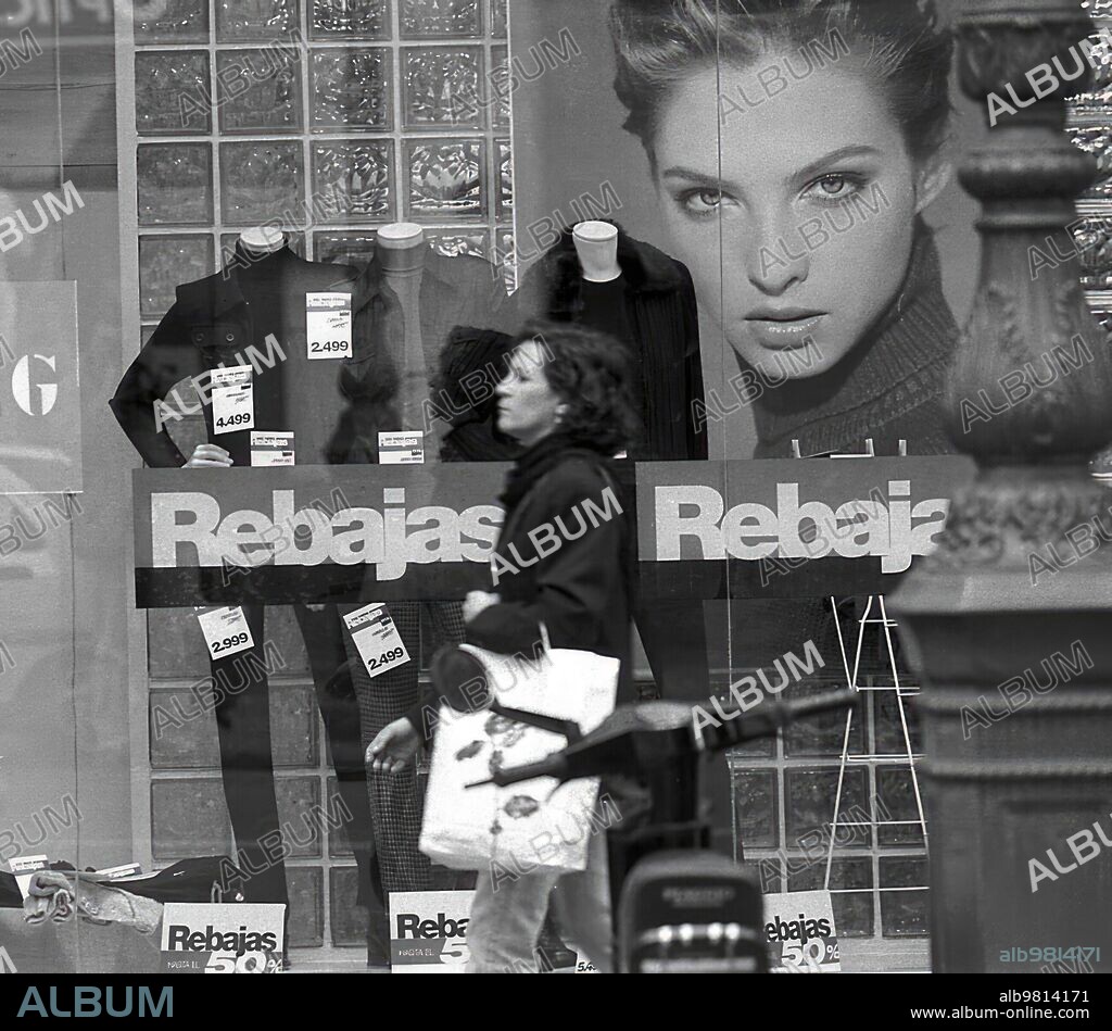 03/01/2000. El reclamo de los carteles anunciando las rebajas en el escaparate de una tienda de ropa.
