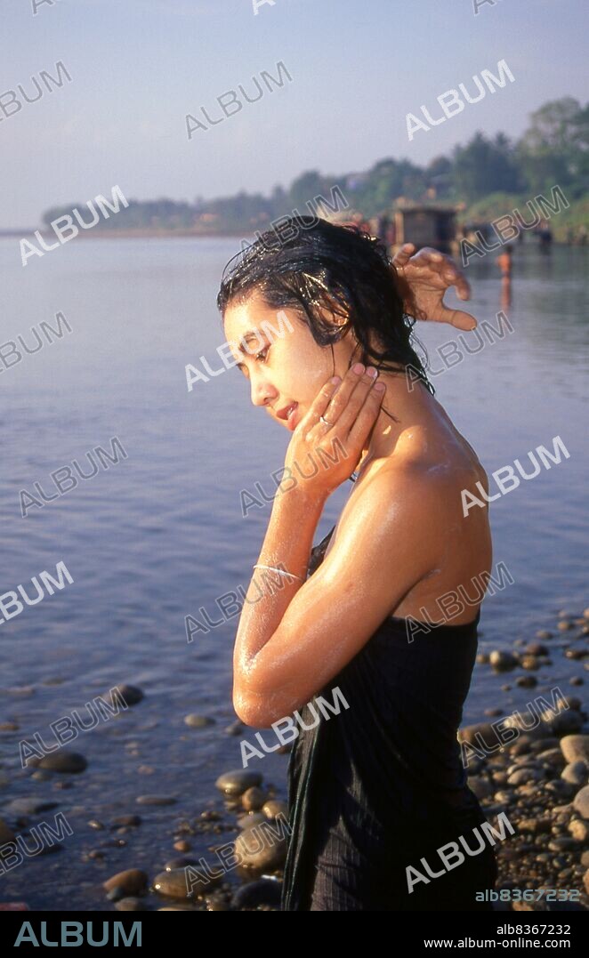 Burma / Myanmar: A Burmese woman bathing in the Ayeyarwady (Irrawaddy) River, Myitkyina, Kachin State (1998).<br/><br/>. The Irrawaddy River or Ayeyarwady River, also spelt Ayeyarwaddy is a river that flows from north to south through Burma (Myanmar). It is the country's largest river and most important commercial waterway.<br/><br/>. Originating from the confluence of the N'mai and Mali rivers, it flows relatively straight North-South before emptying through the Irrawaddy Delta into the Andaman Sea. Its drainage area of about 255,081 km² covers a large part of Burma. After Rudyard Kipling's poem, it is sometimes referred to as 'The Road to Mandalay'.