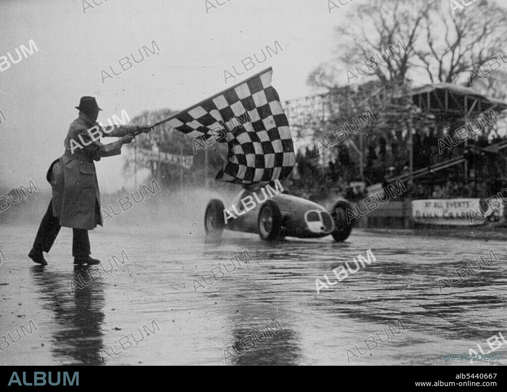 Reg Parnell, 38-year-old British racing driver, flashing by the winning post at Goodwood, Sussex, to win the main event in Britain's first motor-racing programme of the season - the Richmond Trophy. He beat his two rivals, Prince Bira of Siam and Baron de Graffenreid of Switzerland. Only three finished the race of 26.4 miles. Drivers had to battle against driving wind and rain which at times half-blinded them. April 11, 1950. (Photo by Paul Popper Ltd.).