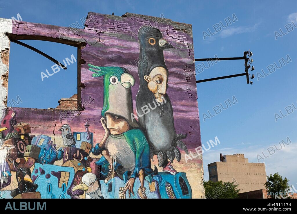 Pintura estilo cómic de dos hombres con disfraz de pájaro, con cielo detrás, graffiti mural, Calle Venezuela, Poblenou, Distrito San Martin, Barcelona, en 2016.